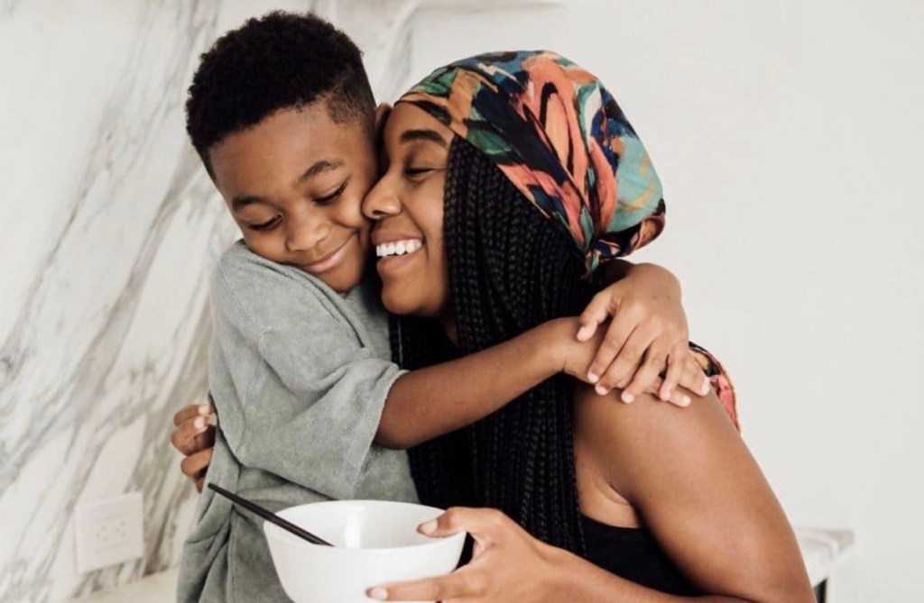 Black mother embracing her young son